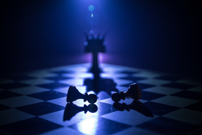 棋盘游戏概念的经营理念和竞争理念以及战略理念。象棋人物在黑暗的背景与烟和雾，窗户与阳光。有选择性的重