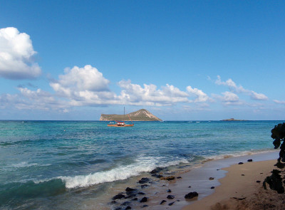 从威马纳洛海滩看，夏威夷风格的双体船在兔子岛航行