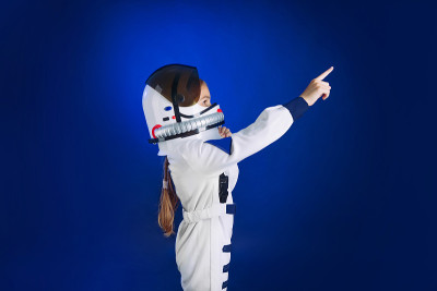 穿着太空服的可爱女孩指着空白的地方发短信