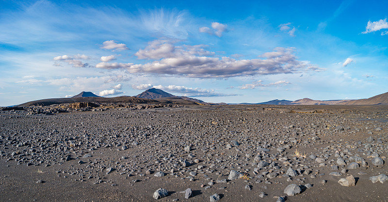 冰岛的全景景观最致命的火山沙漠在高地，石头和岩石抛出，沿着公路徒步旅行，冰岛，夏天，蓝天。