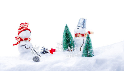 可爱的雪人戴着滑稽的帽子和围巾，杉树深埋在雪堆里