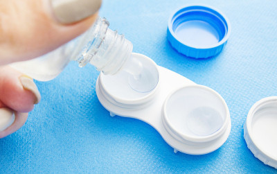 隐形眼镜在一个塑料容器与溶液。