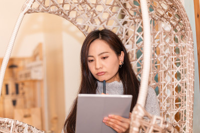 年轻的日本女人在家里看平板电脑