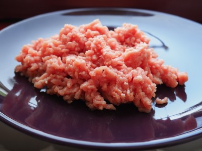 切碎的肉放在一个紫色的陶瓷大盘子里。美味的新鲜碎肉，用于制作肉排，牛排，汉堡，肉丸。猪肉半成品