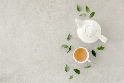 2个白茶杯和茶壶，配绿茶。平躺，俯视图。茶的概念