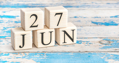 6月27日。木制立方体与日期6月27日在旧的蓝色木制背景。