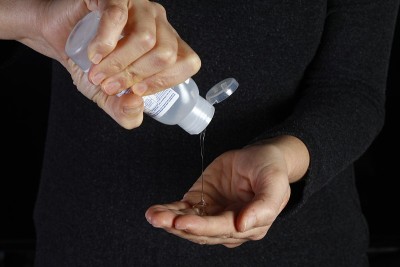 冠状病毒感染的女性双手使用洗手液凝胶分配器，