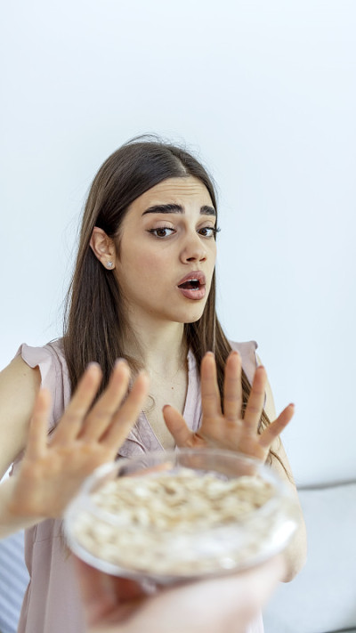 一个漂亮的年轻女子拒绝在家里用碗盛花生。