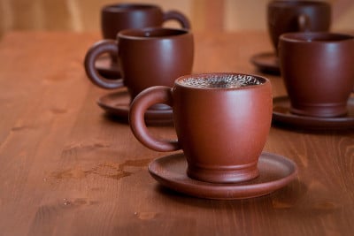 木桌上放着泥茶壶和茶杯