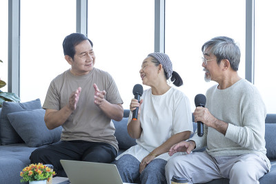 老人们在客厅里唱卡拉ok。老朋友聚会，老人们见面。