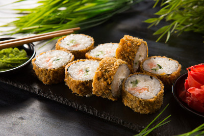 一套炸寿司卷与芥末和生姜在黑色的背景。日本东方美食