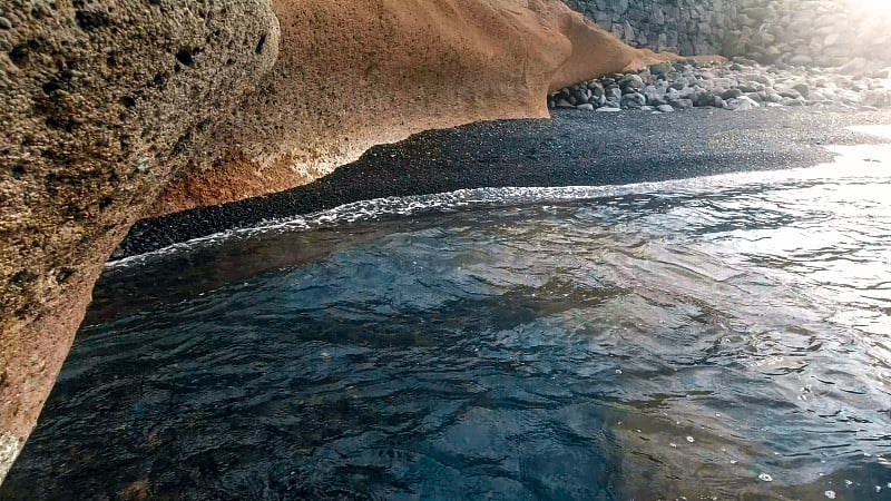 火山海滩上的悬崖峭壁和黑色的沙子