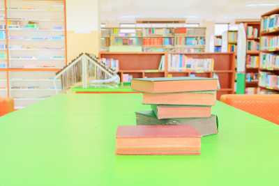 学校图书馆的旧书和堆论文放在桌子上。模糊的书架背景。教育学习理念用拷贝空格加文字