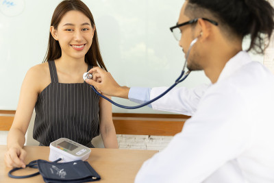 医生的手持视图测量他的病人的压力。医护人员正在为一名年轻人检查血压。