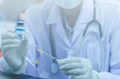 男医生手持一瓶新型冠状病毒疫苗药物或冠状病毒疫苗和注射器