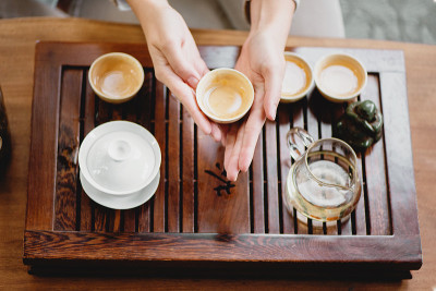 茶道上，手持茶杯的女子