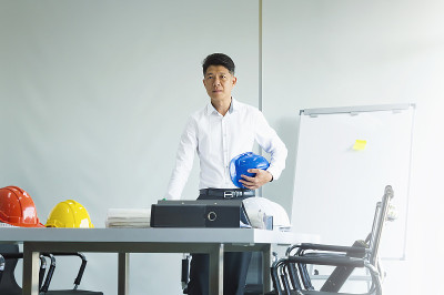 商业工程人看项目建设纸蓝图。