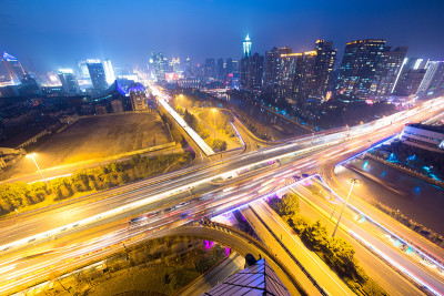 天桥上的交通灯轨迹和夜晚的城市景观