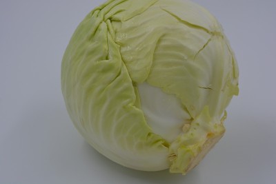 鲜亮多汁的卷心菜，一颗切下来的卷心菜头，夏天的一半乌克兰卷心菜头就坐落在白色的背景上。新鲜健康蔬菜，
