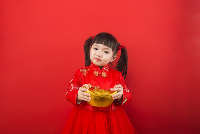 一个中国女孩用金锭庆祝春节。