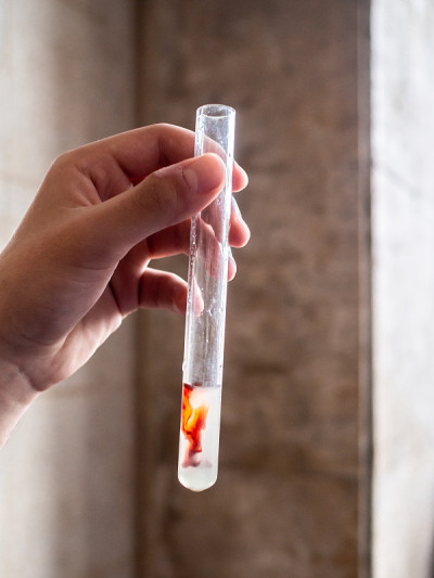 手上拿着化学药品的玻璃试管。在学校实验室做化学实验。化学过程的研究