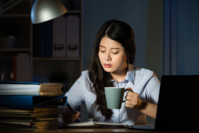 亚洲女商人晚上加班喝咖啡