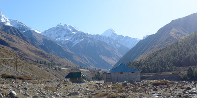 喜马拉雅山上的高山小木屋，为登山者、登山者和徒步旅行者提供庇护。背景中是一个交错重叠的支脉山脊v形山