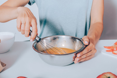 近景女性坐在桌子上烹饪水果蛋糕