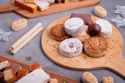 传统的西班牙圣诞糖果铁龙，polvorones, mantecados与圣诞装饰在灰色的桌面