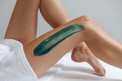 年轻女子脱毛与液体糖在水疗中心