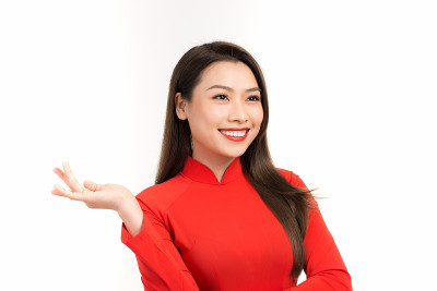 微笑的越南妇女在澳黛裙子拿在她的手