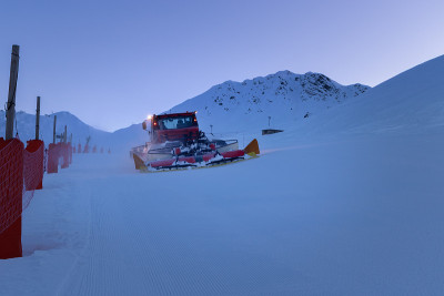 雪整理机准备在黄昏滑雪斜坡。法国阿尔卑斯山的冬季滑雪胜地拉普莱涅