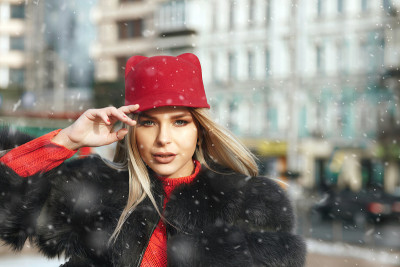 优雅的女士行走在冬天的城市在下雪