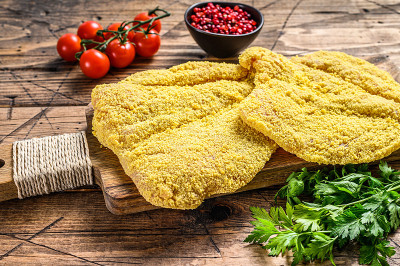 意大利生米兰炸肉排。木制背景。俯视图