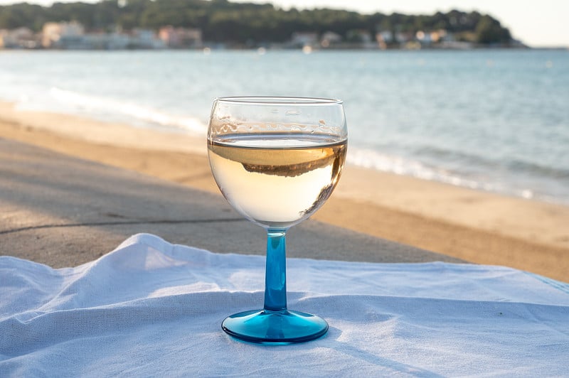 普罗旺斯的夏日，在法国瓦尔省土伦附近的沙滩和蓝色大海上，喝着冰冷的灰玫瑰葡萄酒