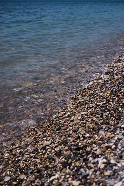 一个波浪滚过布满岩石的海岸。卵石滩。海滨。