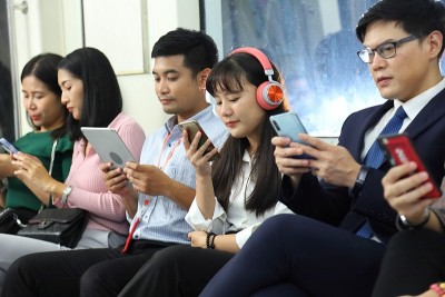 一群亚洲乘客在地铁上使用手机而不和他人交流，因为他们对社会无知、低头和无手机恐惧症