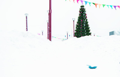圣诞树装饰着红色和银色的蝴蝶结和球，在雪地的背景在公园里的冬天