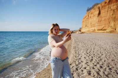 年轻孕妇在海边自拍