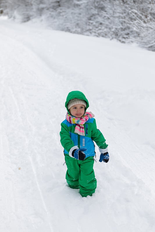 孩子们穿着暖和的衣服在雪地里玩。冬季户外运动。孩子们在冰雪公园里玩耍。