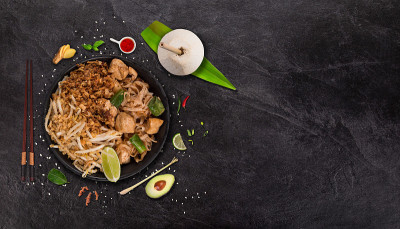 Pad thay亚洲美食背景与各种配料在乡村石背景，俯视图。