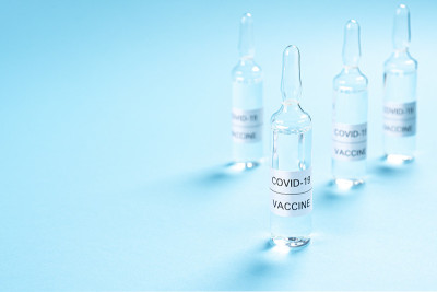 冠状病毒疫苗。蓝色背景的COVID-19药物玻璃安瓿