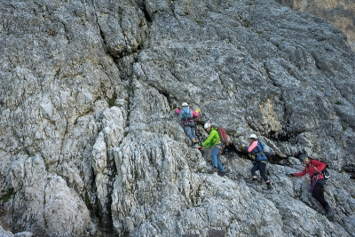 导游和几位客户正在攀登意大利白云岩区的Via Ferrata
