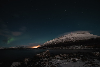 在芬兰拉普兰的Kilpisjarvi，在一个无云的夜晚，北极光扫过一个大湖。绿莹莹的北极光在天空中舞