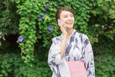 穿着和服用智能手机的女人