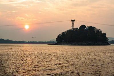 夕阳橙色的天空与河岛的背景在黄昏
