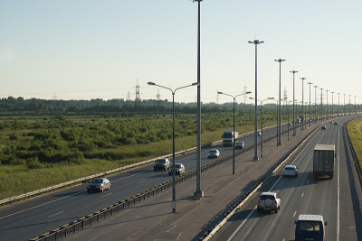 从顶部看一条大型公路，有灯笼和分隔带，汽车在不同的方向