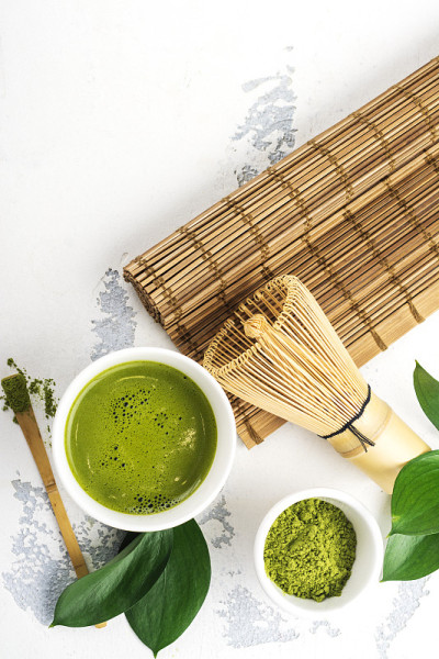 白色背景上的绿色抹茶饮料和茶配件