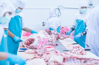 在工厂里切肉的工人