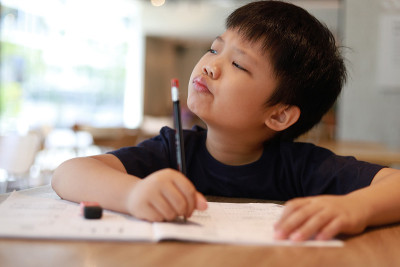 男孩在桌子上写字